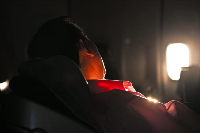 čovjek spava na sjedalu zrakoplova u izlasku sunca